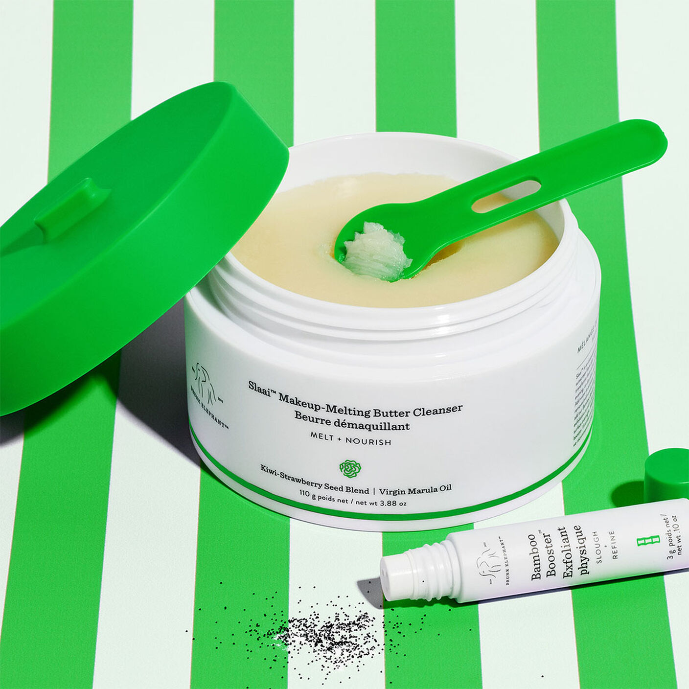 Slaai Make Up Melting Butter Cleanser with the plastic green spatula and the Bamboo booster exfoliant poured out next to it. 