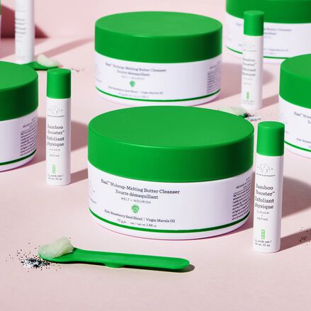 photo de récipients de Slaai et de Bamboo Booster sur surface rose à côté d'une cuillère Slaai montrant les produits