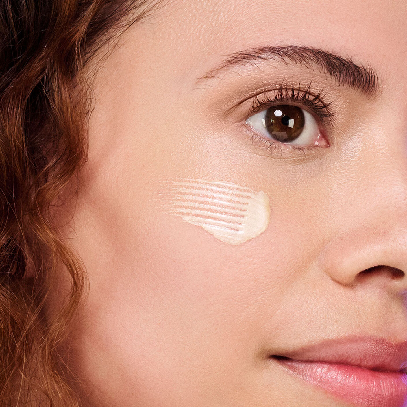 Woman side profile with a swatch of B-Goldi swatched on her face.