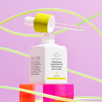 Virgin Marula Luxury Facial Oil's bottle opened with dropper lying on top