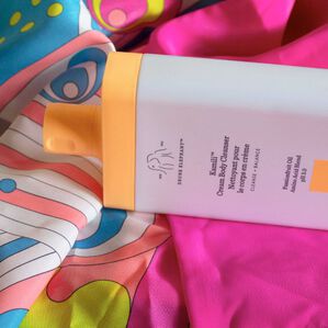 photo of a Kamili body cleanser bottle nestled in the folds of a Drunk Elephant Drunk Life Robe