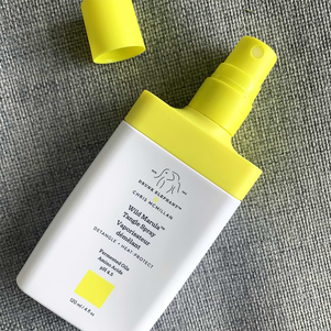 tangle spray bottle with its cap off on a gray canvas surface