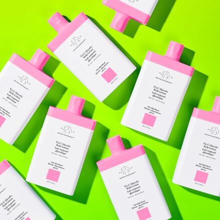 photo de multiples flacons de lotions glycoliques pour le corps T.L.C. sur un fond vert
