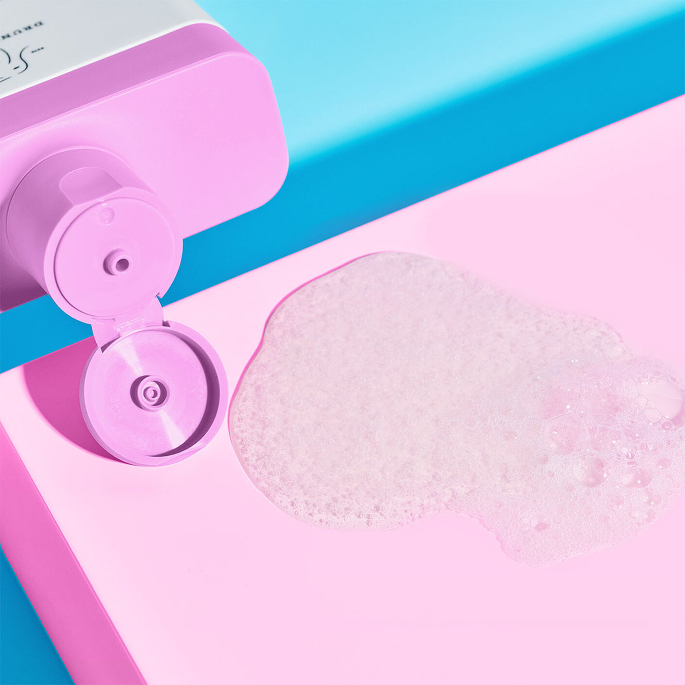 Close up Scrubbi Bamboes Body Cleanser bottle and goop on a pink table. 