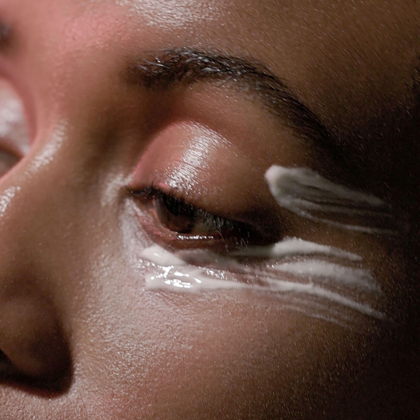 La zone des yeux et des joues d'une femme avec le sérum pour les yeux A-Shaba Complex appliqué sous les yeux et sur les tempes.