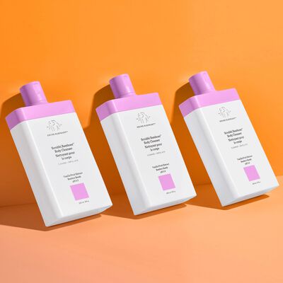 Three Scrubbi Bamboes™ Body Cleansers tilted against an orange background