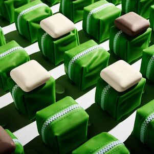 photo of several baby bar duo zipper cases aligned in a grid on a white surface some with baby pekee and baby juju bars on top