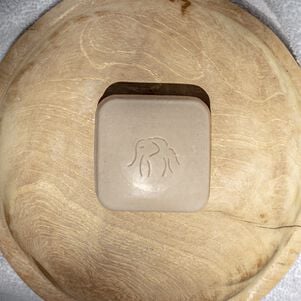 photo d'un pain nettoyant Juju Bar sur un plateau en bois rond