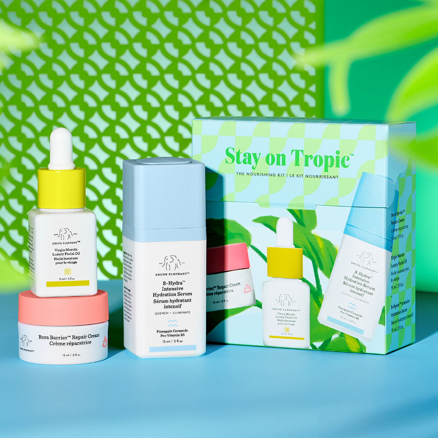 Produits Bora Barrier, B-Hydra et huile Virgin marula posés debout devant l’emballage de la trousse sur un fond imprimé vert