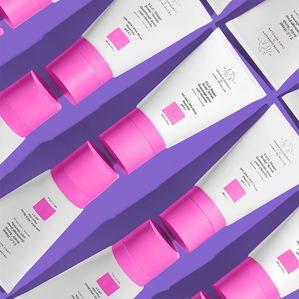 photo de plusieurs flacons de gommage pour cuir chevelu disposés contre un fond violet