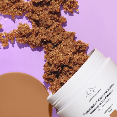 Sugared Koffie™ Almond Milk Body Scrub against a blue background with product in front