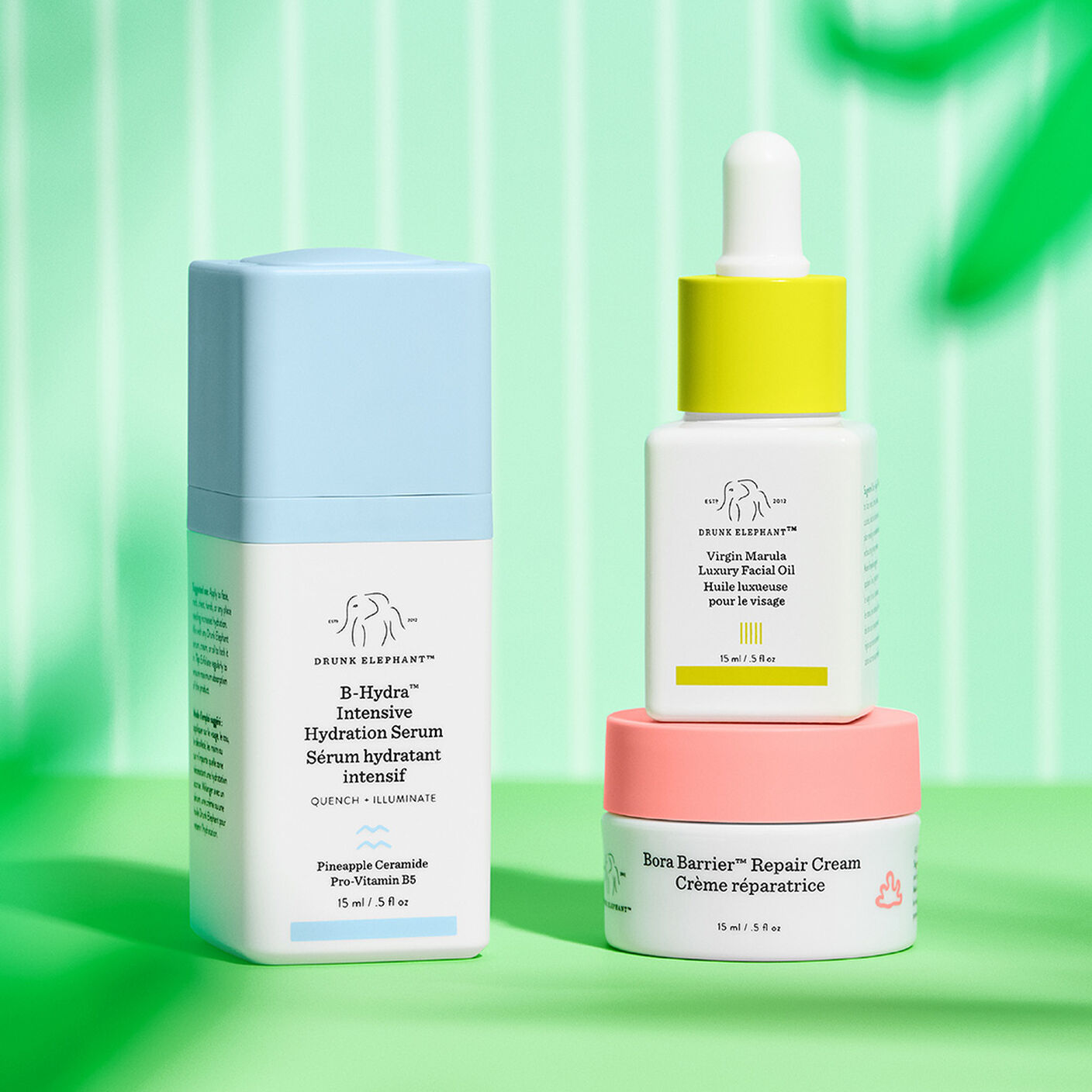Produits Bora Barrier, B-Hydra et huile Virgin marula posés debout davant un fond à rayures vertes