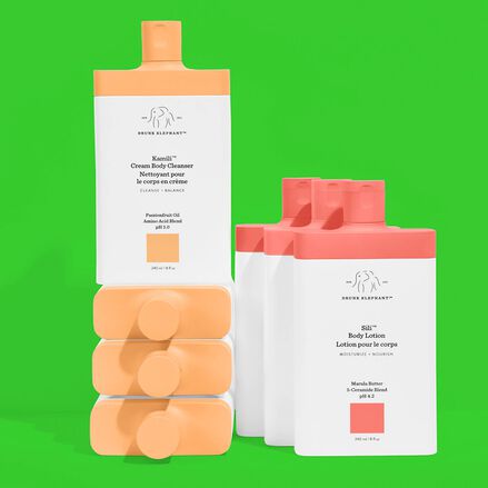 photo of a stack of Kamili body cleanser bottles next to a column of Sili body lotion bottles against a bright green background
