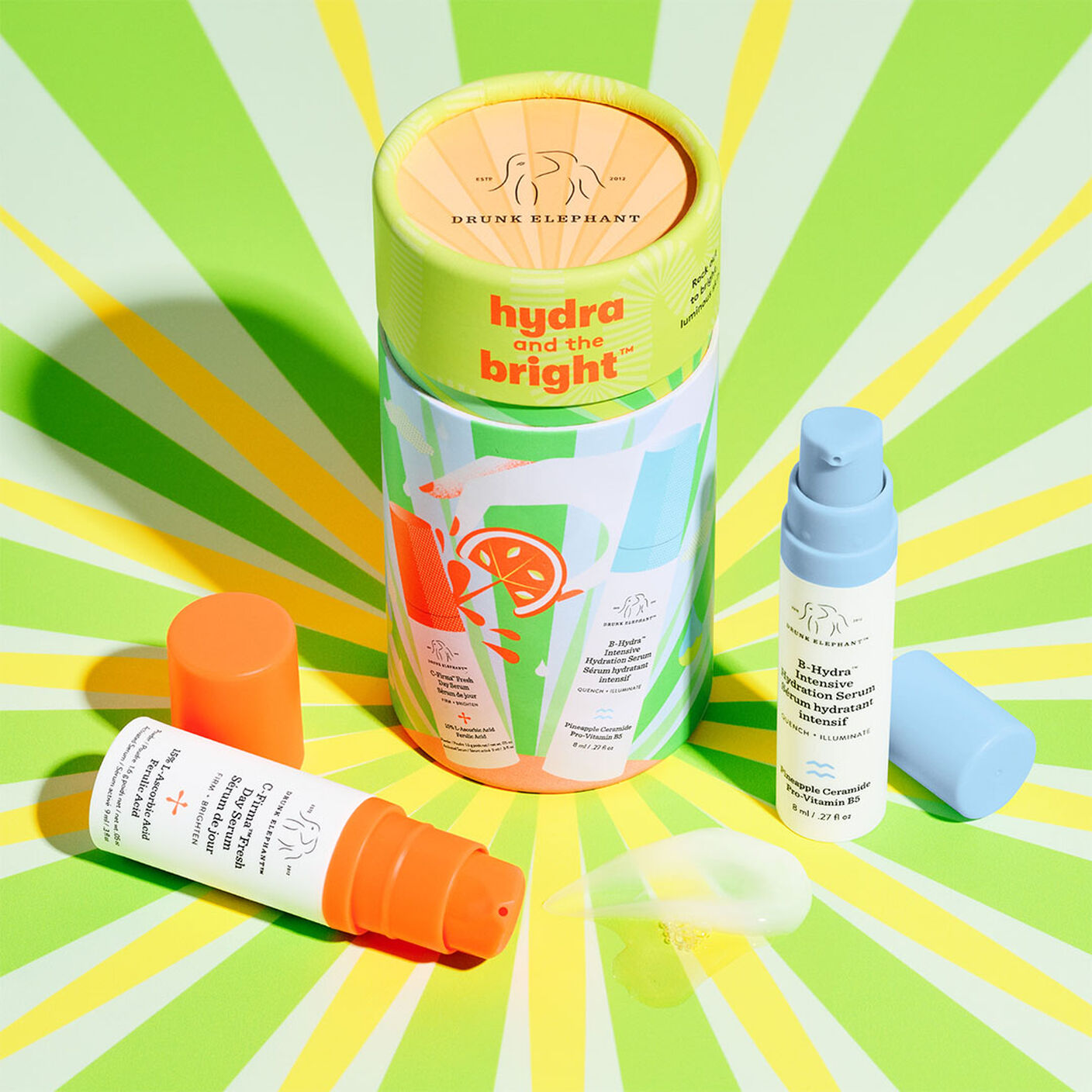 Emballage Hydra et the Bright avec C-Firma Fresh et B-Hydra avec les bouchons retirés et avec des sérums étalés à côté.